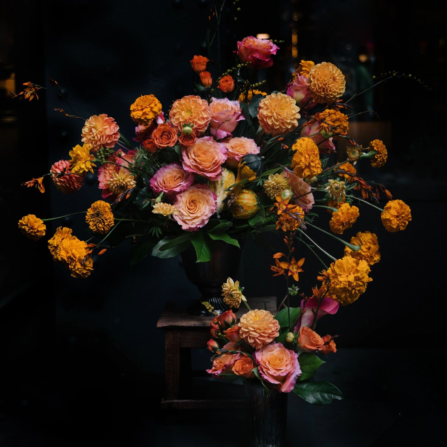 in this arrangement the dahlias keep the chalice of the celestial Sun. They fly lightly around Mexican marigold. The orange shade with sparks of roses and ranunculus adds brightness to its chaste beauty.